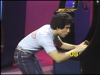 Nolan playing Galaga during the taping of Starcade.
